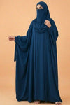 Person wearing a blue abaya against an orange background