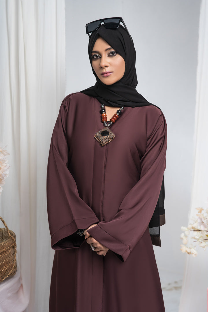 Zoom-in view of front detailing on maroon jilbab abaya, modest and simple abaya design for women