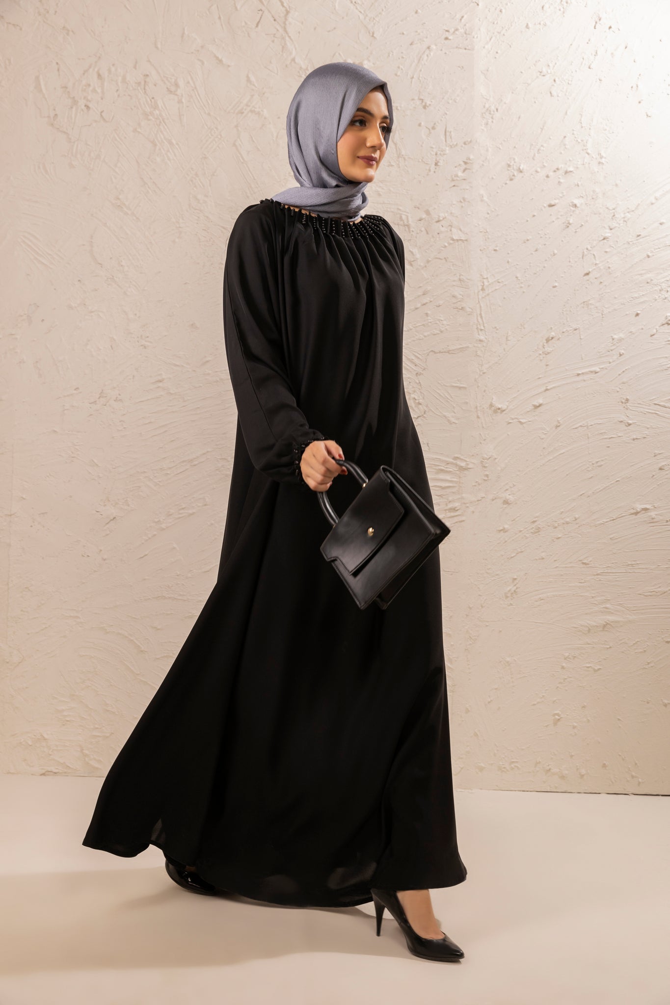 Elegant side full view of black abaya featuring pearls on neckline, modern modest fashion abaya for women in Pakistan