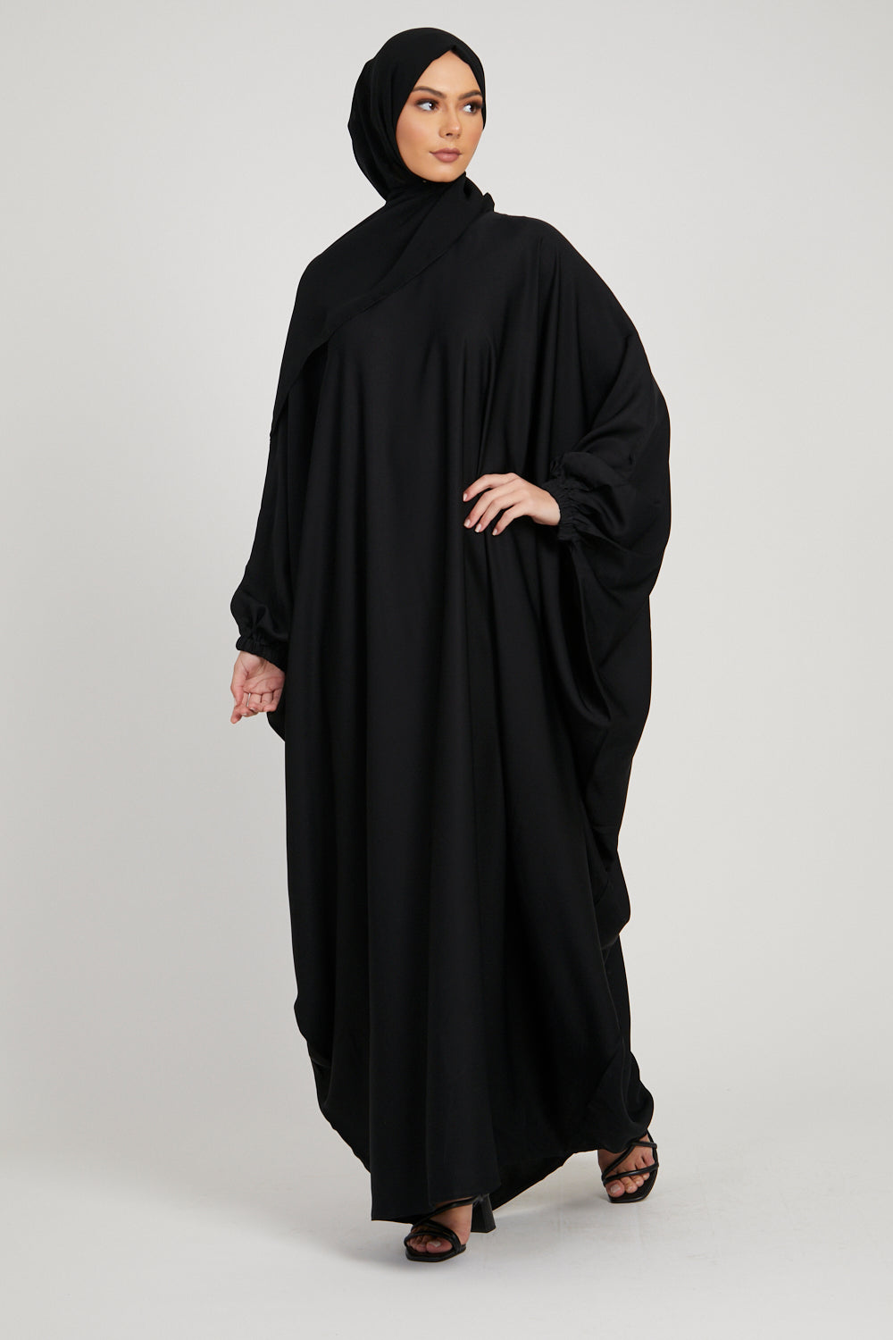 Front full view of stylish black kaftan abaya with elastic cuffs, modest fashion outfit for women in Pakistan